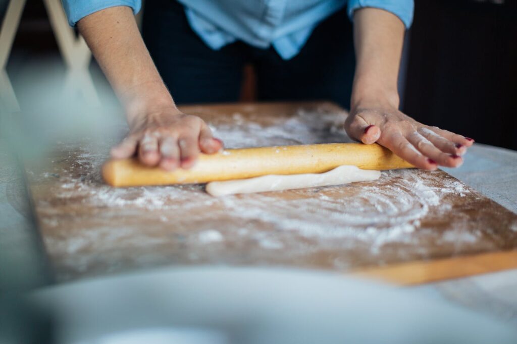 Person Holding Brown Wooden Rolling pin